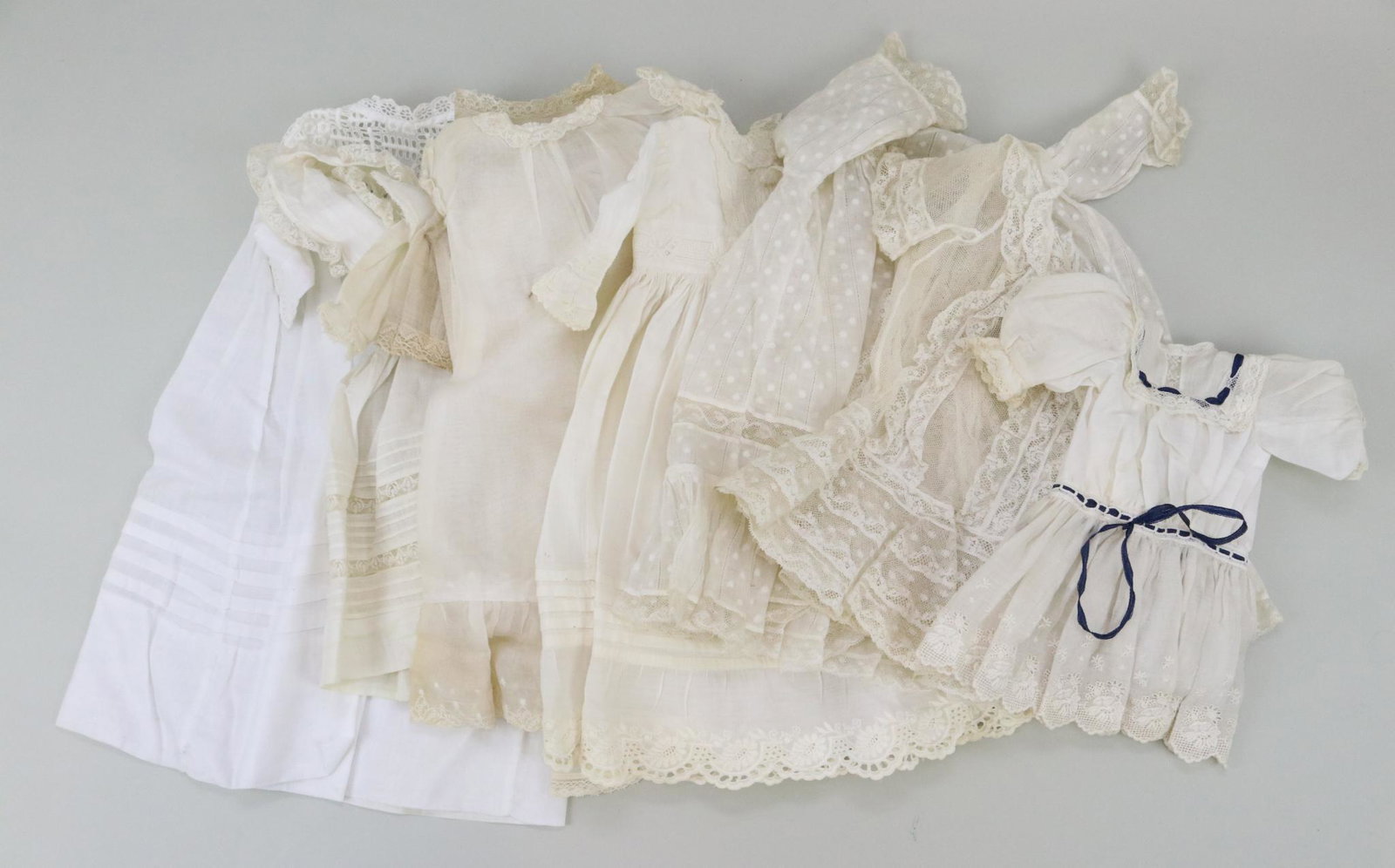 ANTIQUE/VINTAGE DOLL CLOTHING.: Lot of antique white cotton doll clothing. 14" Pinafore. (2) Factory chemises 13", 15". Dresses - 9 1/2" dress, 12" (tulle/lace), 12" (dotted Swiss/lace), 15" dress, 14" baby dress with petticoat, 16 