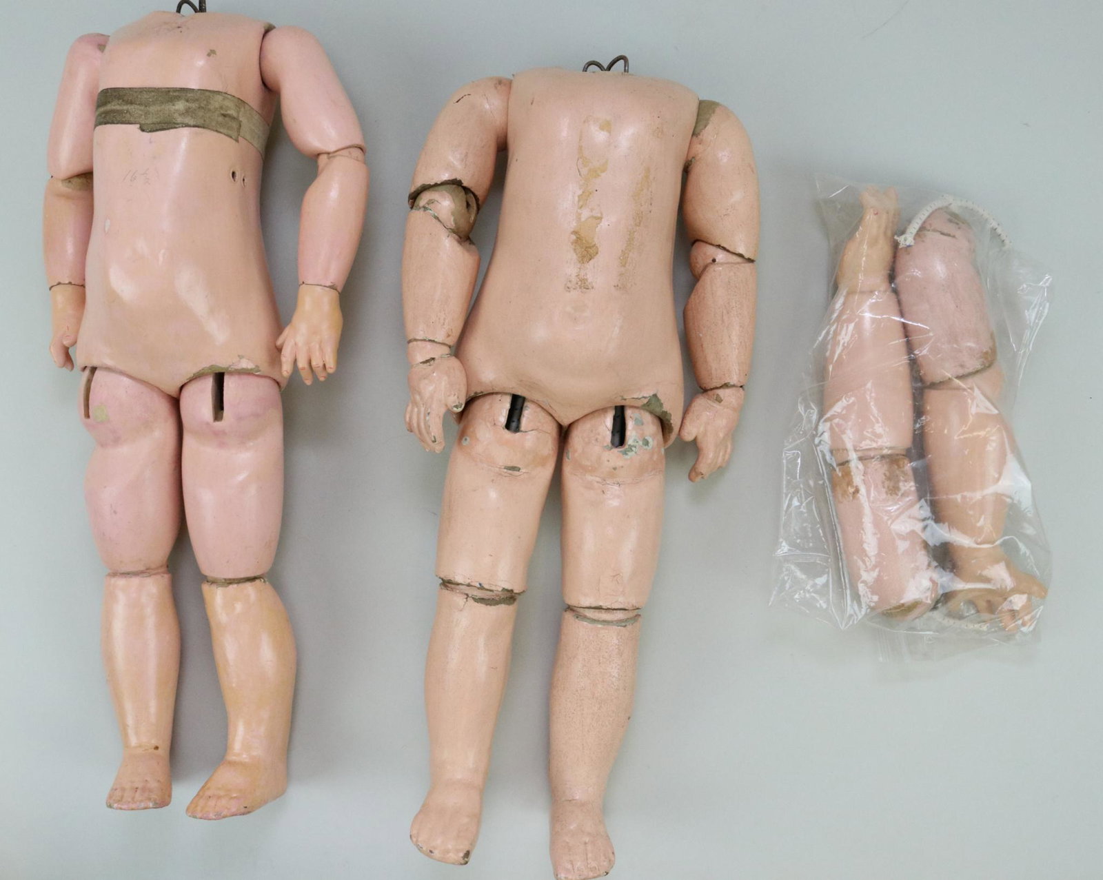 LOT OF ANTIQUE DOLL BODIES.: Pair of papier mache French bodies. 16" Body is marked (blue stamp) JUMEAU Medaille D'Or PARIS. 16 1/2" Body is unmarked. It has the hole on the back of the torso and the holes for the pull cords for 