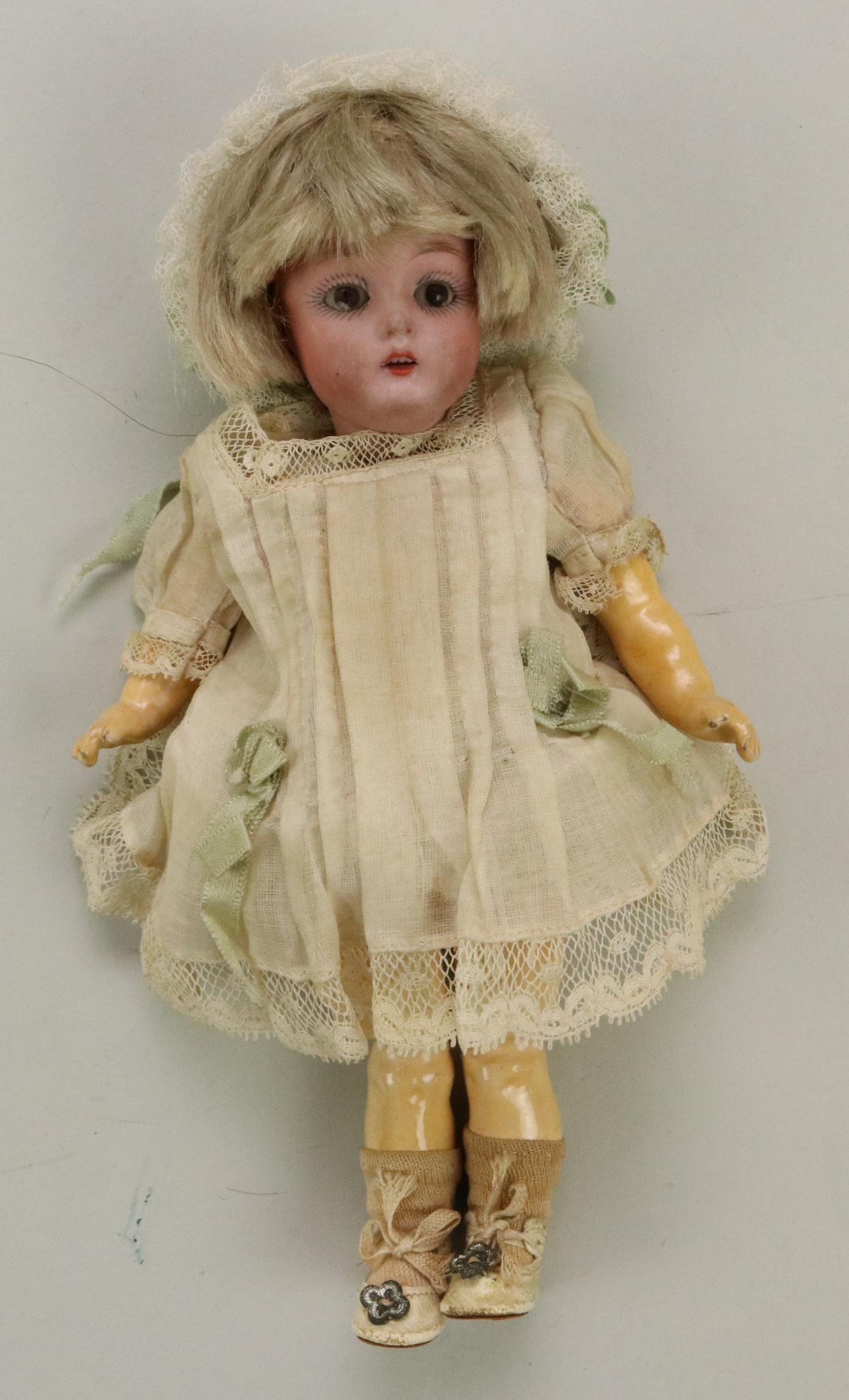ANTIQUE BISQUE HEAD DOLL(S), 12" AND UNDER.: 7" K. Made in Germany 6/0 155 with brown sleep eyes, open mouth, blonde mohair wig. 1 Pc. papier mache arms with ball at shoulder, fully jointed legs. Dressed in antique white dress, petticoat, pantie