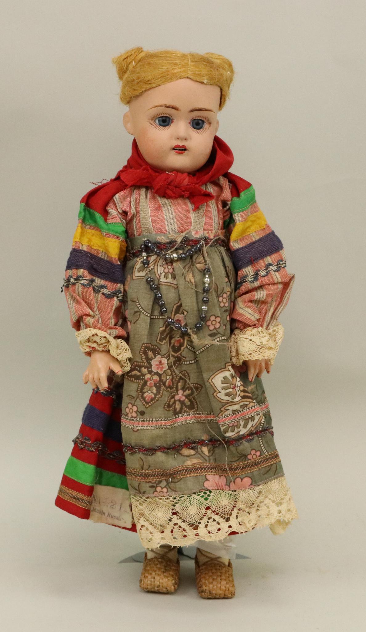 ANTIQUE BISQUE/OTHER HEAD GERMAN DOLL.: 14 1/2" "36"? (Mark illegible) Fired clay head doll with blue sleep eyes, open mouth, flax wig with two top knots. Papier mache jointed body. Dressed in all original regional Russian outfit with decor