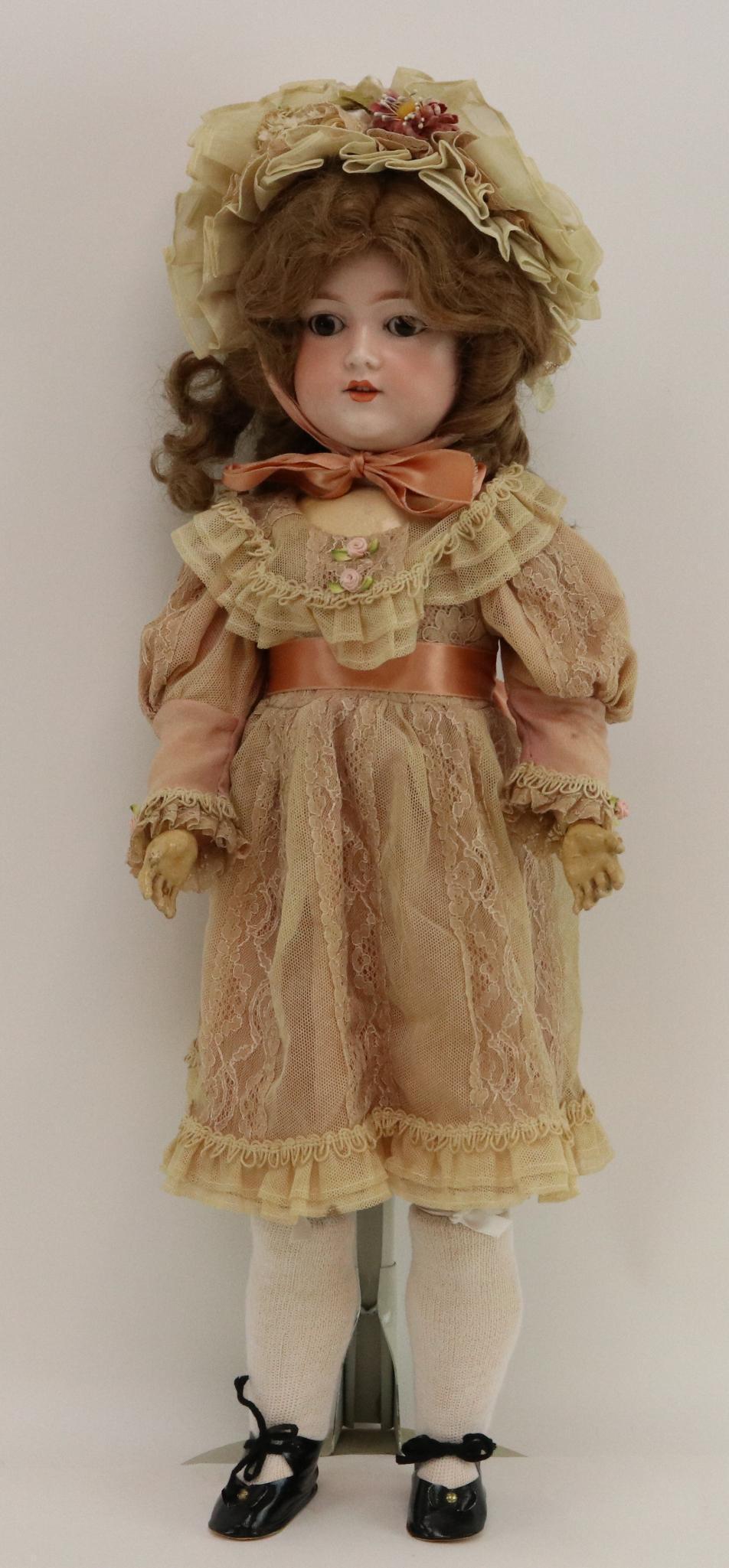 ANTIQUE GERMAN BISQUE DOLL.: 24" GERMANY G.B. doll with stationary brown eyes, open mouth, brown synthetic wig. Papier mache ball jointed body. Dressed in vintage ecru lace/tulle dress over a pink silk liner with matching bonnet.