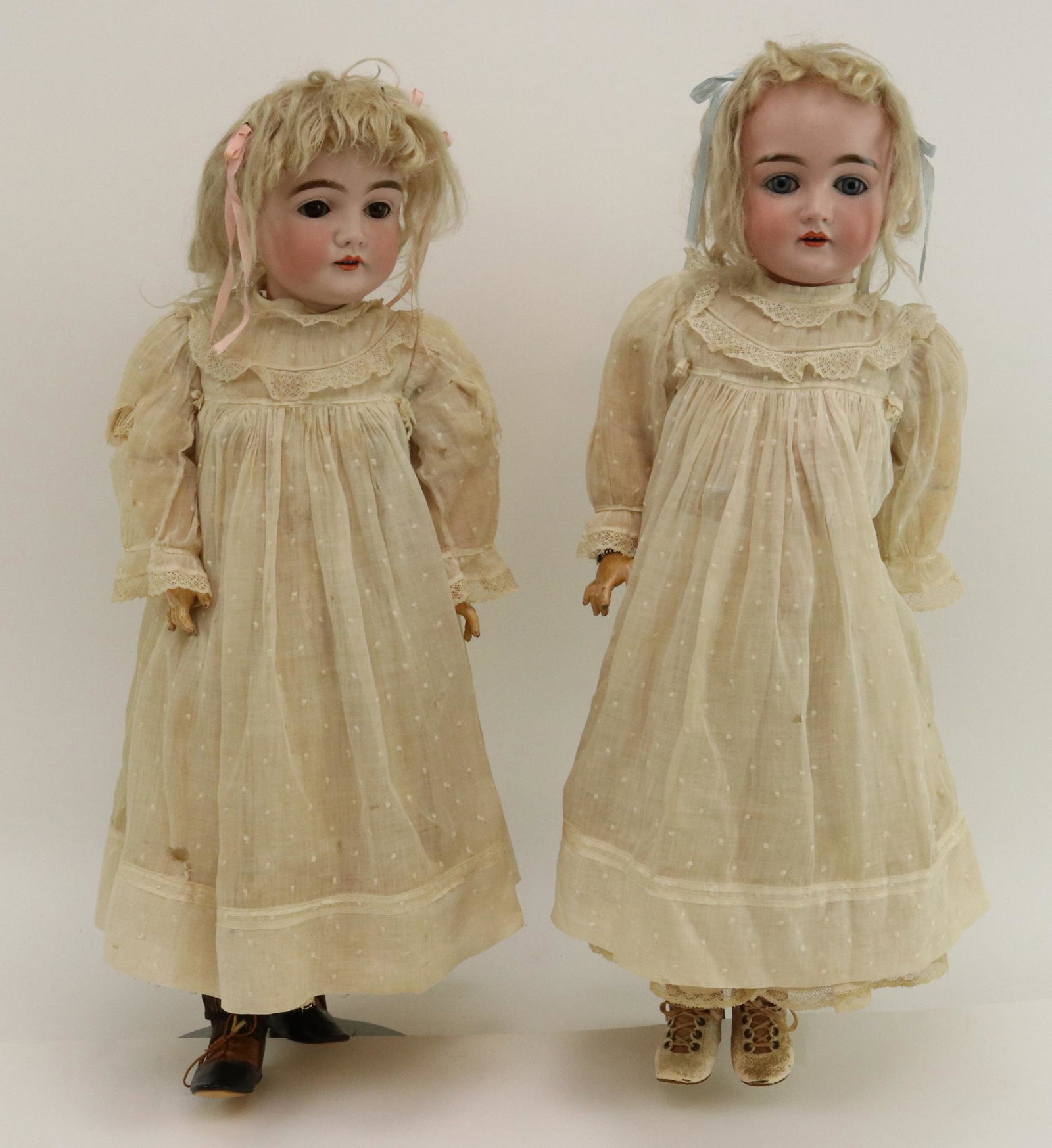 ANTIQUE GERMAN BISQUE DOLL(S).: Pair of 25" MADE IN GERMANY 14 146 twin dolls. (1) Has blue eyes, the other brown. Both have open mouths, blonde mohair wigs, plaster pates. Papier mache ball jointed bodies. Both are dressed identica