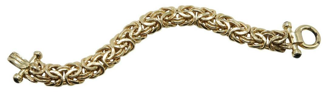 14KY Gold Black Onyx Bracelet: 7" long flat Byzantine link bracelet with black Onyx cabochon terminals on clasp ends. Multiple dents. 17.9gtw.