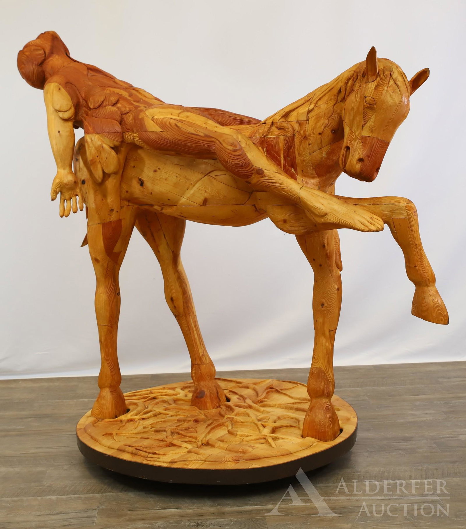Wayne Forbes (1945-2013): Wood sculpture, "Harbinger," horseman #1. Surreal carving of horse with winged human rider in reclining position. Proper left thigh of horse branded with "1". 53"h x 58"l x 34"w