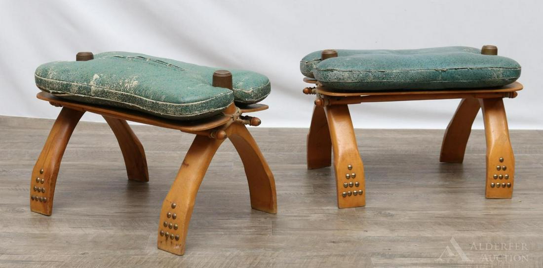 Camel Saddle Stools: Pair of stools/benches with wood and distressed leather seat. Brass studs on legs. Stamped "Made in Yugoslavia" and small decorative stamp of a camel, pyramid and pharaoh. 15"h x 21"w x 12"d