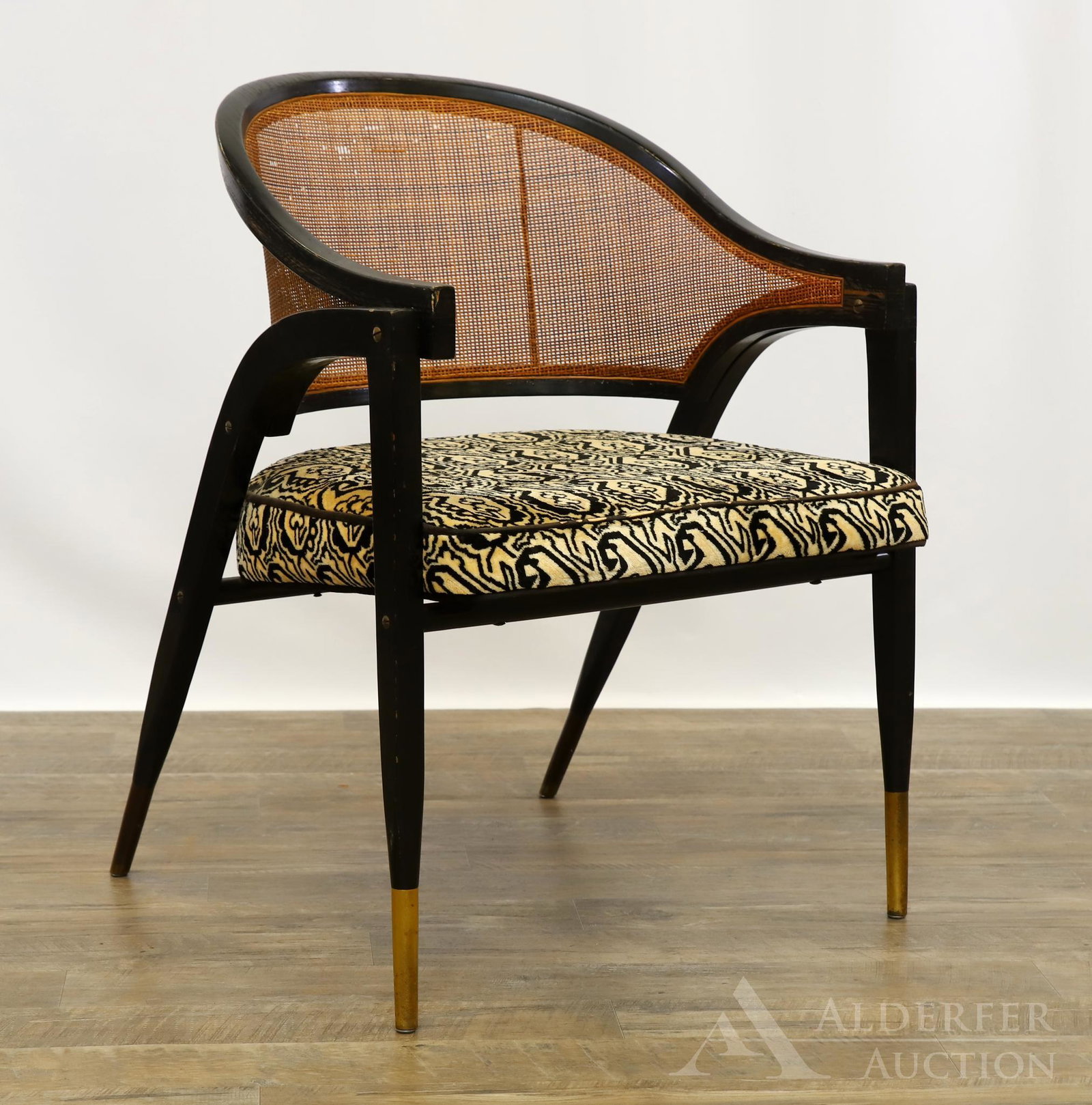 Edward Wormley for Dunbar Arm Chair: Ebonized frame and cane back on tapered legs with brass ferrules. Retains original upholstery. 32"h x 25"w x 24"d