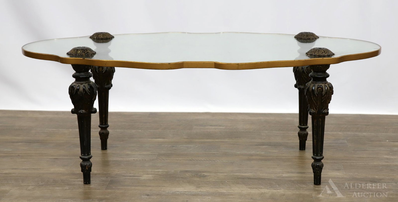 Monteverdi Young Glass Top Coffee Table: Scalloped glass edge table resting on carved ebonized and tapered legs. 16"h x 46"w x 28"d