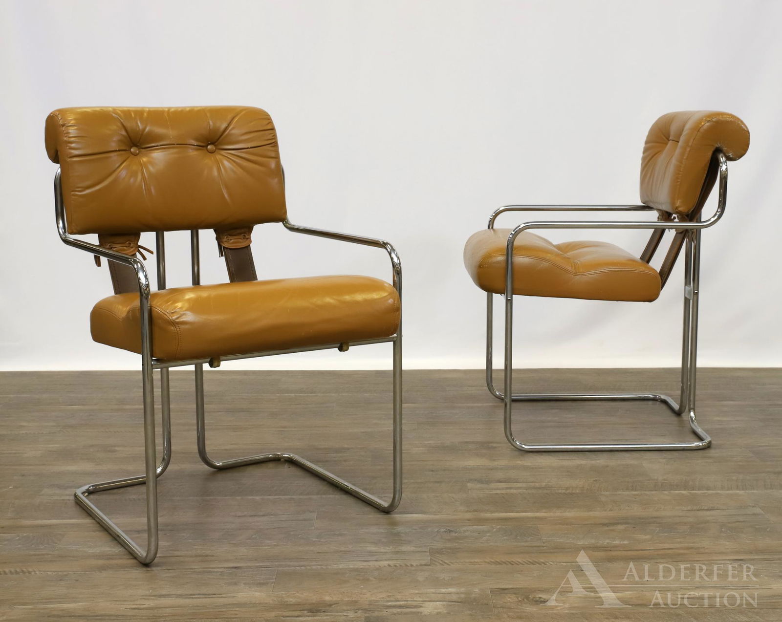 Pair of Italian Chrome & Leather Arm Chairs: Chromed steel tubular frame with tufted leather rolled back cushion and tufted seat cushion of the same material. Marked "Made in Italy". 32"h x 21"w x 22"d