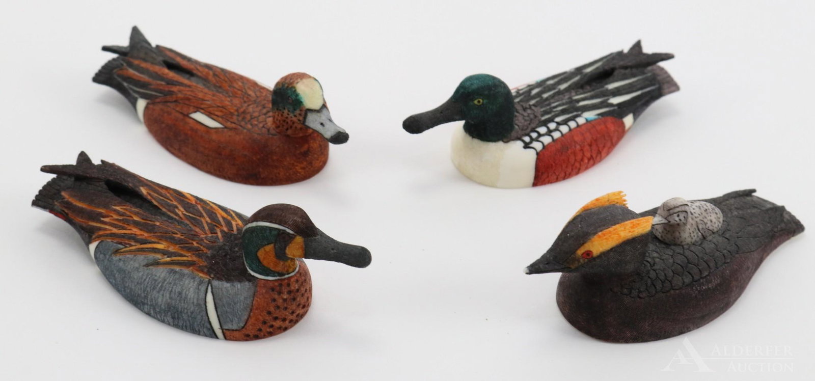 Scrimshaw Carvings: Grouping of (4) Alaskan scrimmed and carved ducks all signed and dated by Ted Mayac, Jr. Includes Horned Grebe with chick, American Wigeon, Baikal Teal, and a Shoveler. Approx. 4"