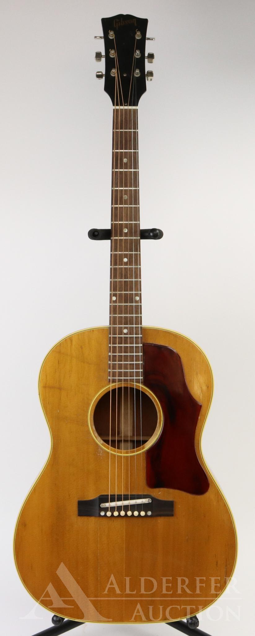 Gibson Acoustic Guitar: 1963 Gibson B-25-N acoustic guitar. Small body. Serial # 103985. Exhibits some crazing/crackling to finish. Top has a split from bridge to base of body. However, split has been repaired and cleated on