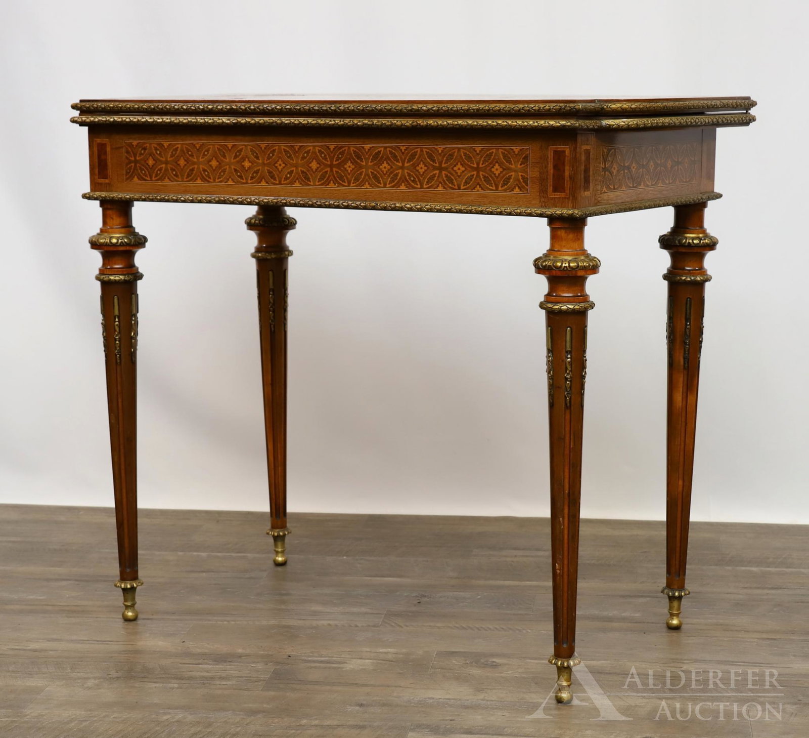 French Ormolu Mounted Games Table: Fruitwood with floral, c-scroll, and acanthus marquetry and parquetry, and banded inlay decoration. Green velvet inset playing surface on tapered fluted legs. 30"h x 35"w x 36"d (open)