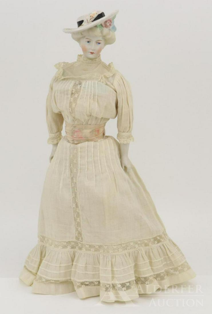 LOT OF CHINA/PARIAN DOLL(S).: 18" Marked parian-type 1941 "Gibson Girl" doll by artist EMMA CLEAR. Modelled shoulder plate with flowers that are also in her blonde hair. White straw wide brim hat with wide black band and floral de