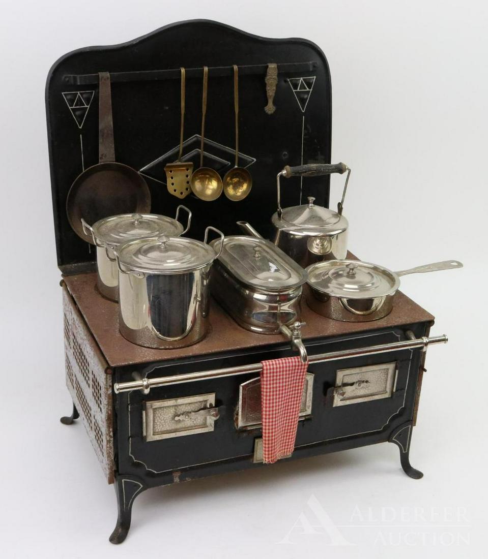SALESMAN'S SAMPLE STOVE.: Wonderful metal stove with a full accompaniment of polished cookware and hanging accessories. Includes: (2) lidded pots, lidded pan, water chamber, kettle, skillet. Perforated side tables fold down. 2