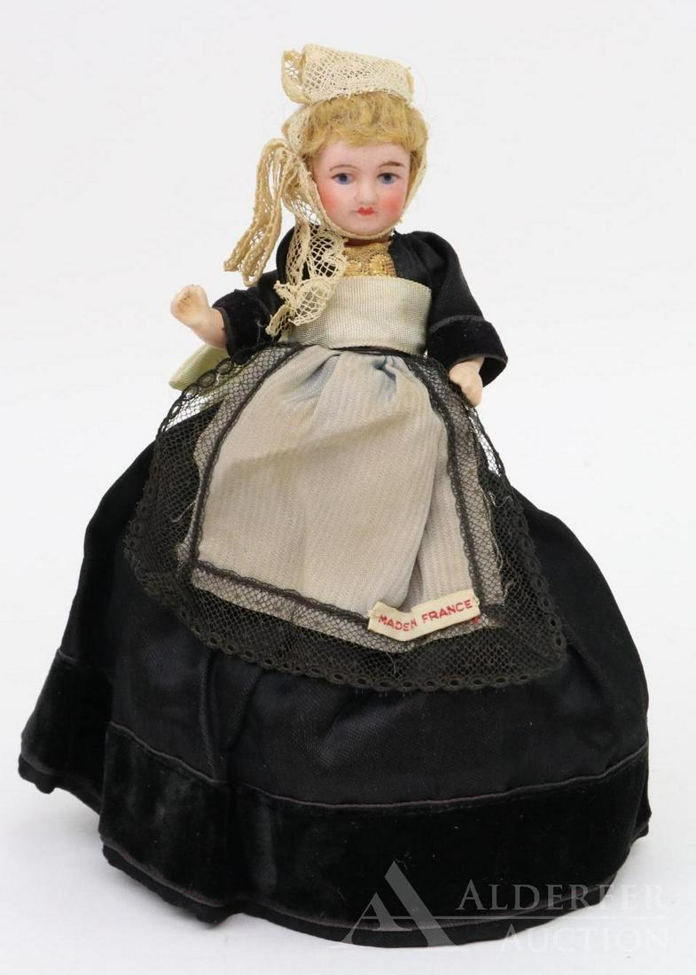 ANTIQUE FRENCH BISQUE HEAD (NOVELTY) DOLL.: Candy box. 7" All original candy box with UNIS FRANCE head, Papier mache arms but the rest of the body is covered up. She has painted features, blonde mohair wig. Dressed in regional costume of black 
