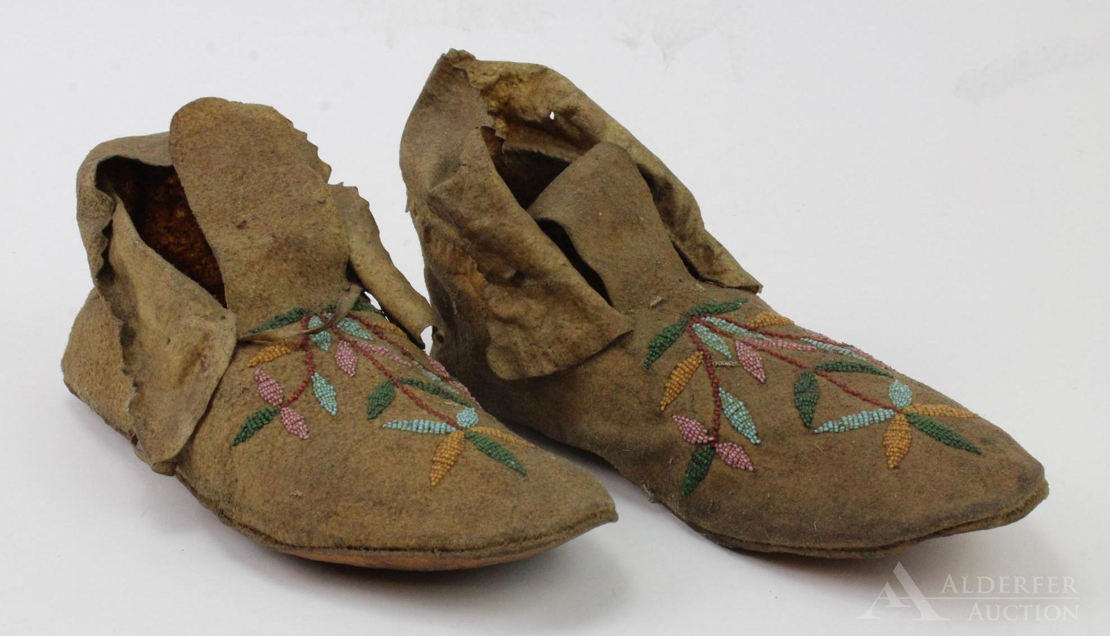 Pair Beaded Leather Moccasins: Cuffed hide moccasins with beaded flower design on front. 10" length