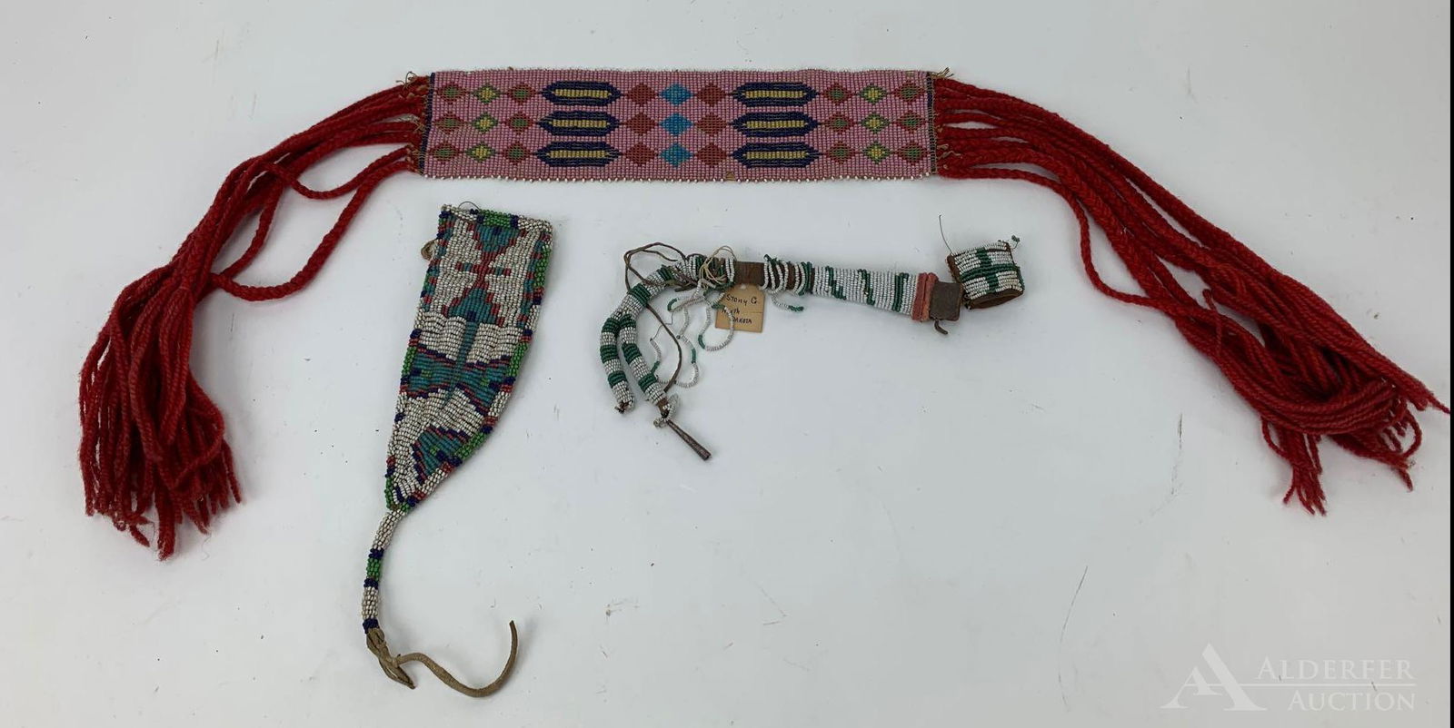 Native American Beaded Grouping: Includes beaded sash with geometric design and red yarn fringe, 11" length. Beaded leather knife sheath, 8.5" length (includes beaded tail). Beaded awl case with lid, poor condition.