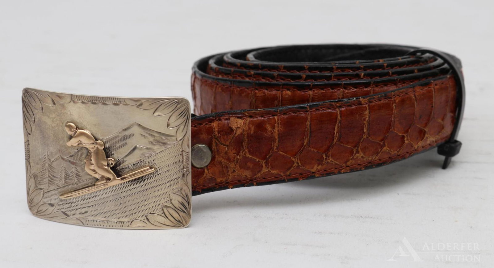 Sterling and 14k Gold Belt Buckle: Hand chased sterling buckle with a 14k gold downhill skier. 1.25"h x 2"w
