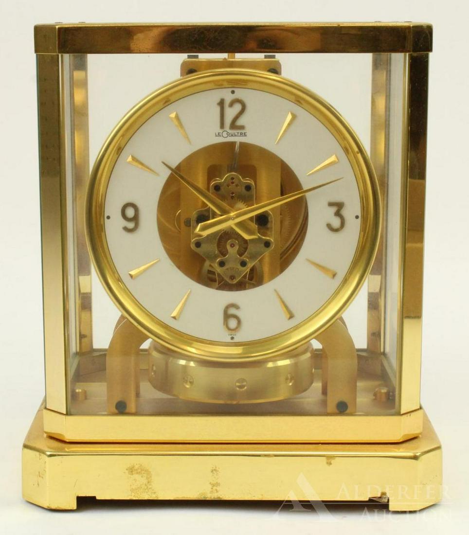 LeCoultre Atmos Clock: Jaeger LeCoultre Atmos swiss made perpetual motion clock with exhibition case in brass, with four panes of glass, and white dial. 9.25" h x 8.25" w x 5.75" d.Â