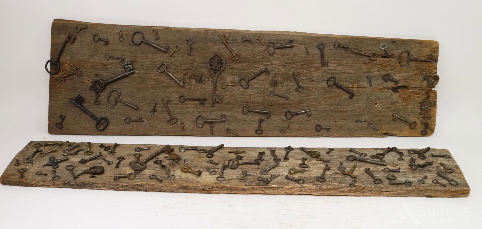 Mounted Keys: Grouping of (2) boards with mounted antique keys and locks in a variety of sizes and styles. Boards measure 40" length x 7"w and 39" length x 12"w.