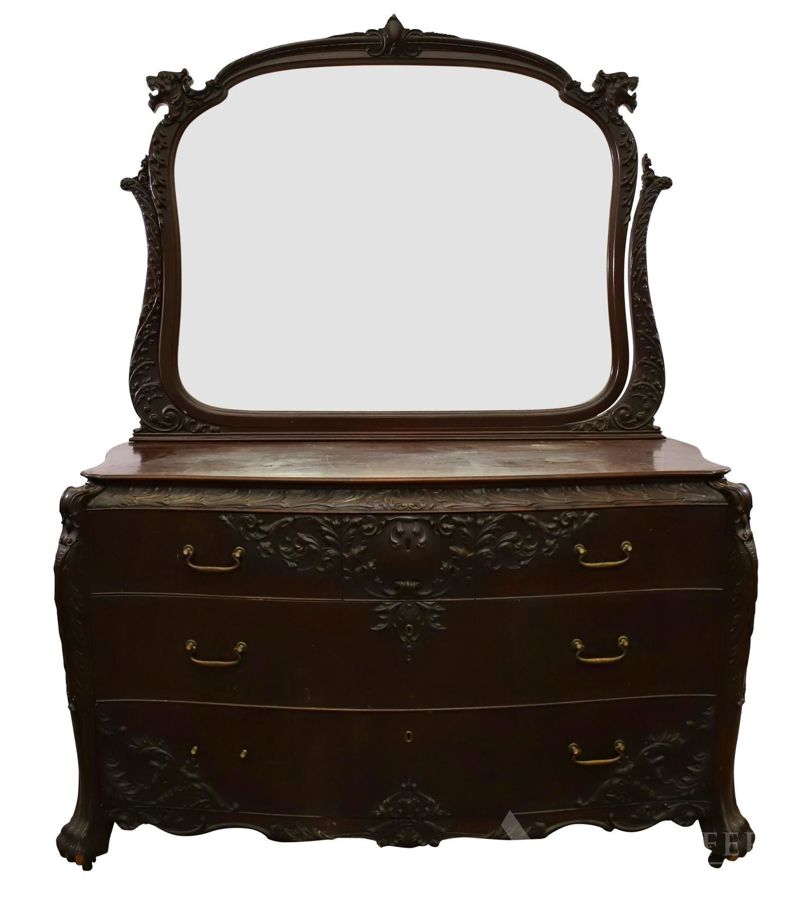 Heavily Carved Mahogany Dresser: Dresser with three graduating drawers with simple brass pulls. Scroll work carving on edges and corners, animal paw feet with casters and attached mirror. Not including mirror 33"h x 55"w x 21"d, with