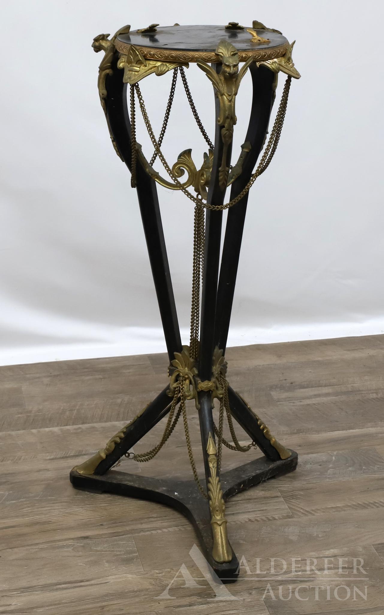 Ormolu Mounted Gargoyle Motif Pedestal: C-scroll acanthus and floral highlights with swag chains, ebonized tripod base with hoofed feet. Missing one mount. 31"h x 16" w x 16" d