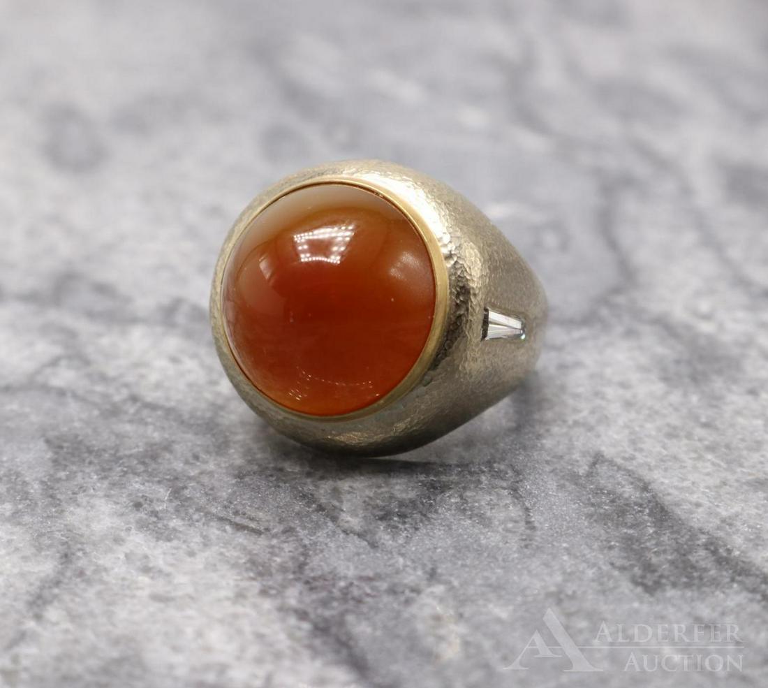 14KW and 18KY Gold Carnelian and Diamond Ring: Textured 14K white gold ring features (1) 16mm round bullet top Carnelian cabochon set in an 18K yellow gold bezel flanked by (2) 7 x 2.5 x 2mm tapered baguette Diamonds, approx. .32ctw, one Diamond 
