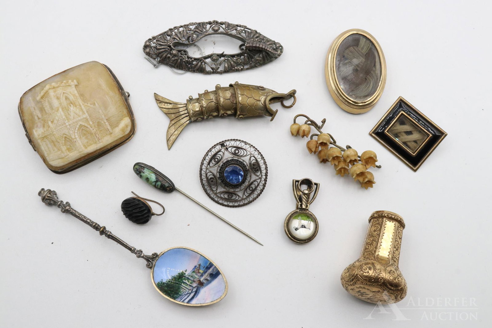 Victorian Mourning Jewelry and Extras: Grouping includes a pair of Mourning jewelry pendants, carved landscape brooch, sterling brooch with a terrier, articulating fish, gold filled 19th c. walking stick cap, stick pins, souvenir spoon, et