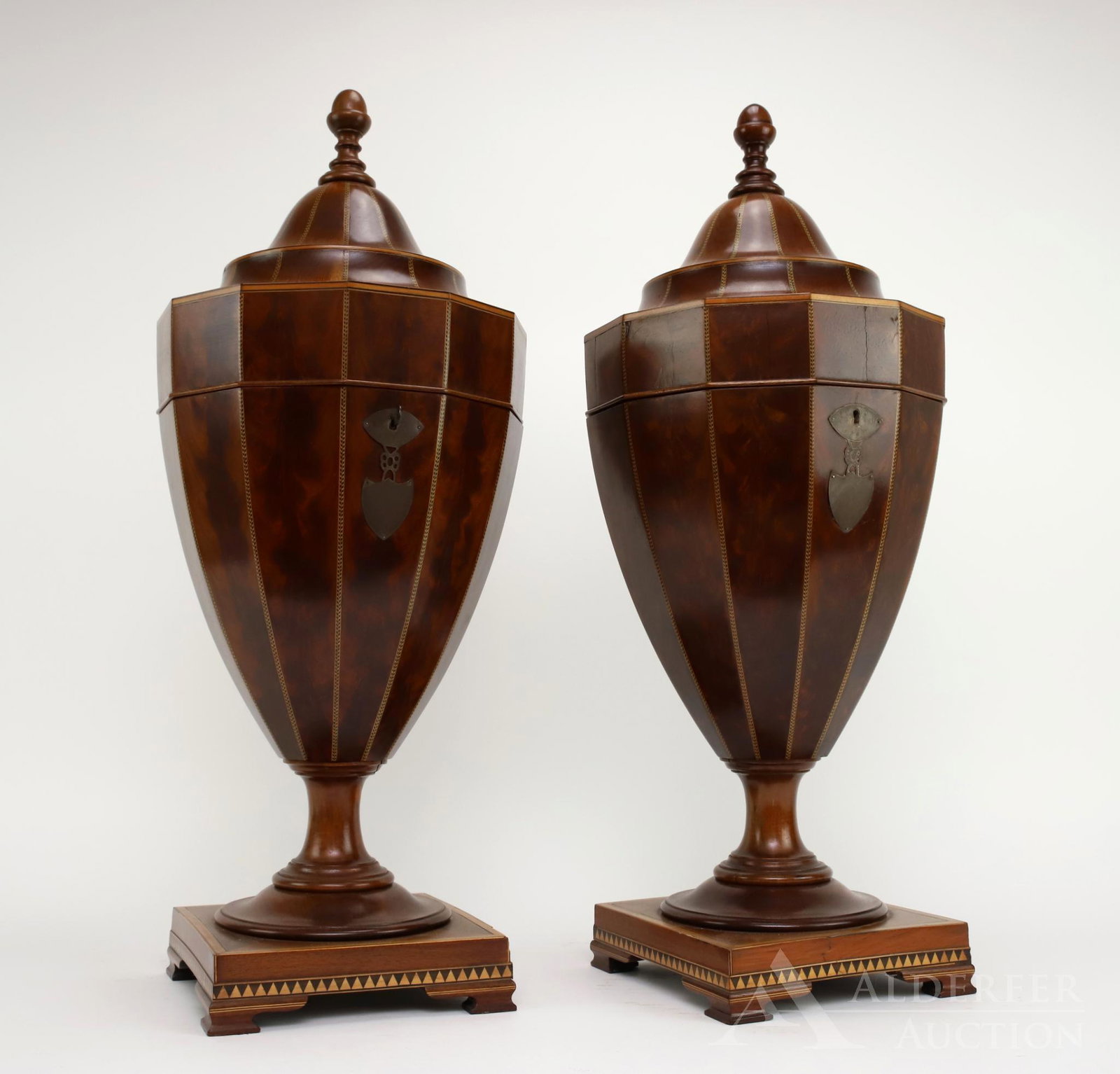 Federal Style Knife Boxes: Federal style inlaid urn knife boxes having geometric string inlaid decoration and acorn finial over urn form. Body on a square base all set on ogee bracket feet, top lifts to reveal original fitted m