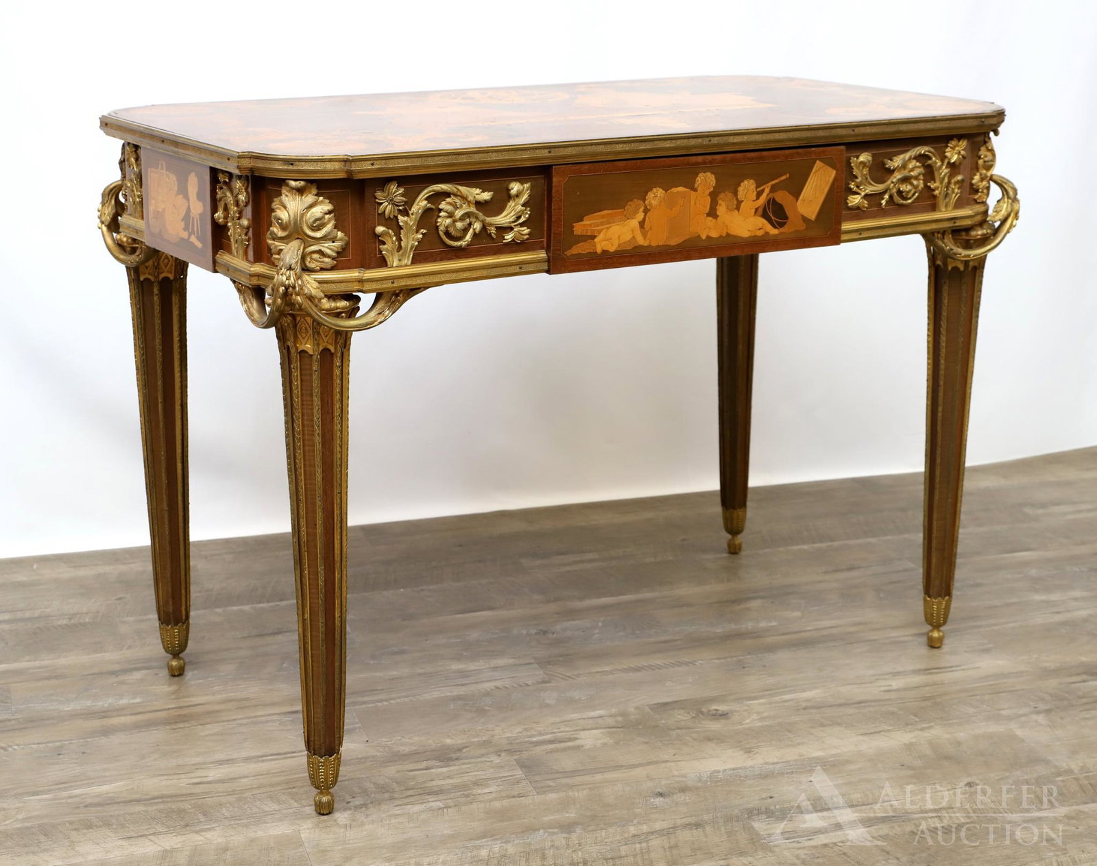 French Marquetry and Ormolu Mounted Writing Table: Ornate classical figural and foliate marquetry top, sides, and drawer with foliate ormolu mounts on fluted tapered legs. 30"h x 43"w x 24"d