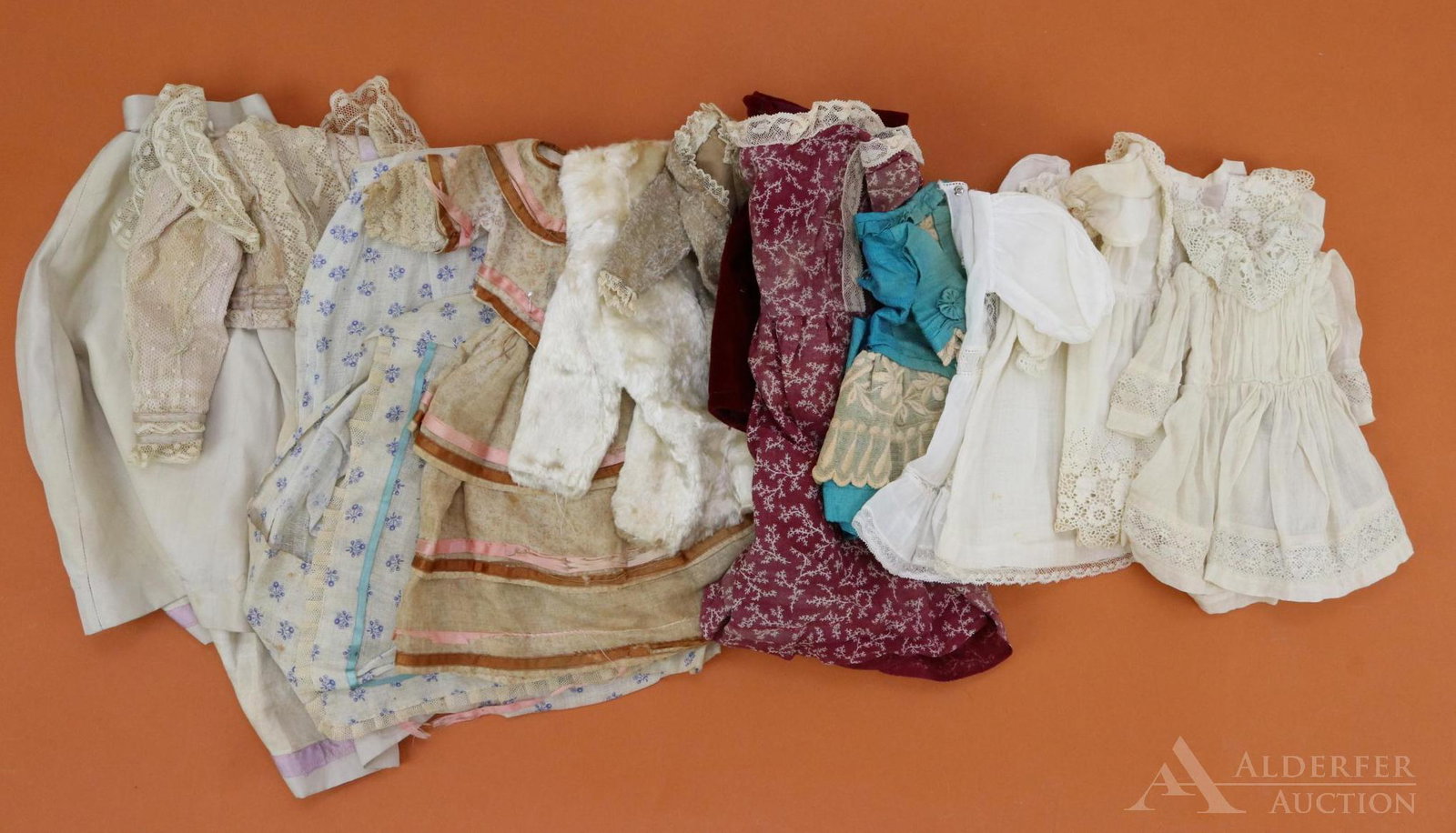 LOT OF ANTIQUE/VINTAGE CLOTHING.: Lot of antique/vintage doll clothes. (4) 9" White cotton dresses. 7" Aqua silk dress, 13" print cotton dress. (Age fading, discoloration). Pair of 2 pc. outfits. Skirt with (2) bodices. (2) Jackets/co