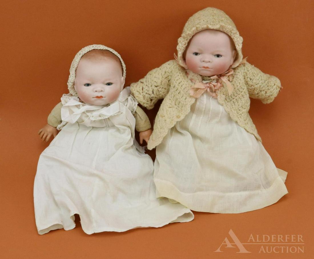 BYELO BABY LOT.: Pair of dolls with 10 1/4" circ. bisque heads. Both dolls are marked Copr. by Grace S. Putnam. Both dolls have celuloid hands, original stamped cloth "frog" bodies. BLUE eye doll has darker hair and a