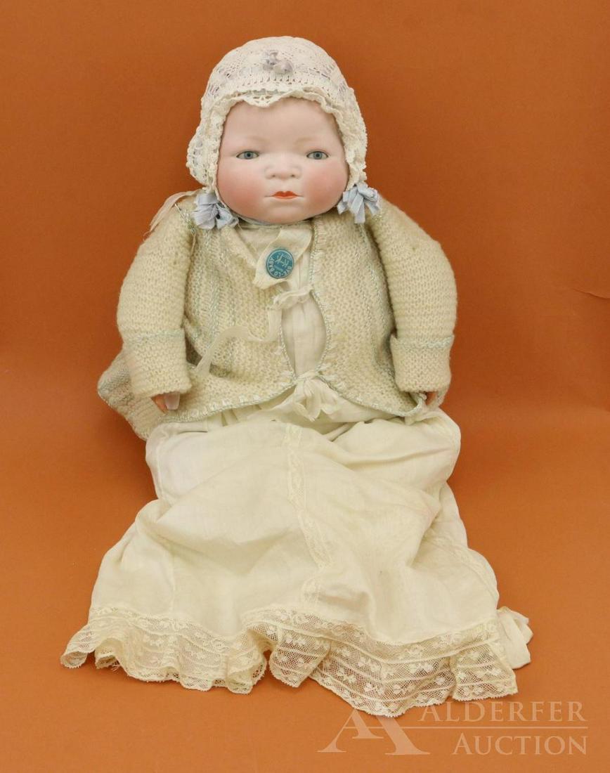 BYELO BABY LOT.: 15 1/2" Circ. bisque head doll marked Copr. By Grace S. Putnam Made in Germany. BLUE eyes, celluloid hands, original marked cloth "frog" body. Dressed in original tagged K and K BYE-LO Baby gown with 