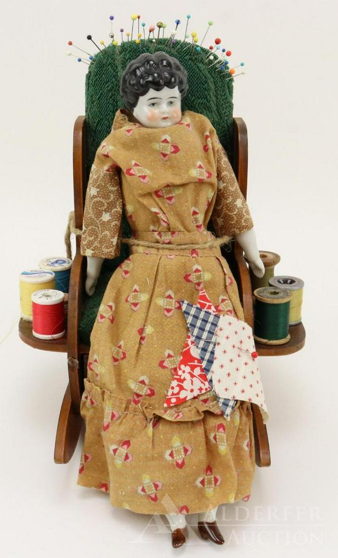LOT OF CHINA/PARIAN DOLL(S).: 12" China shoulder head Low brow doll with black hair. Dressed in vintage clothing. She is sitting on and tied into a vintage wooden upholstered rocking chair. She is representing a sewing doll with s
