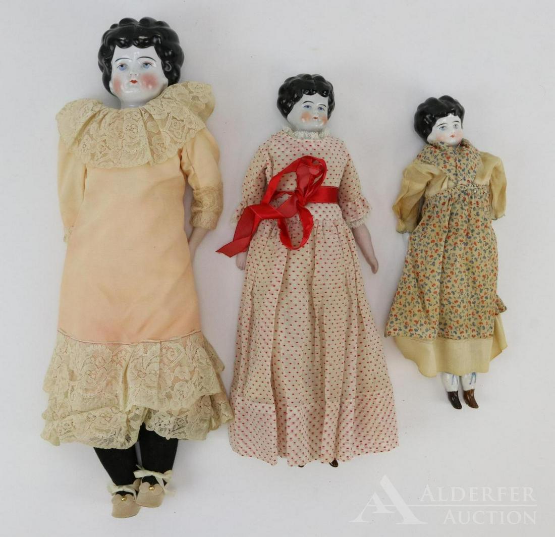 LOT OF CHINA/PARIAN DOLL(S).: Lot of (3) china shoulder head Low brows with black hair. 13" Doll is marked 1 Germany. Antique cloth body, china lower limbs with painted blue bows on garters. Antique clothing. 16" Doll is marked Ge