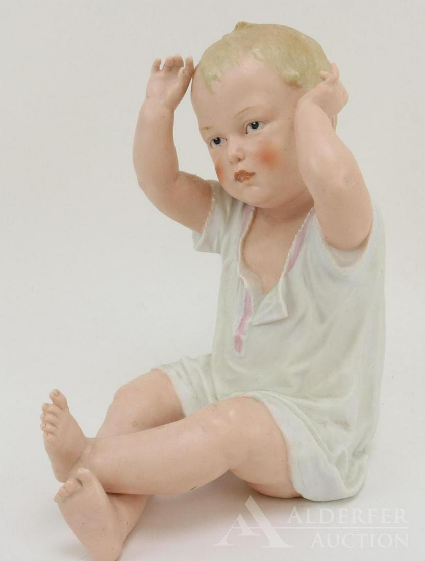 BISQUE FIGURINE LOT: 9" T HEUBACH sitting piano baby. Unmarked. Blue integlio eyes. Condition: mold imperfection on left wrist otherwise, nothing observed on bisque.