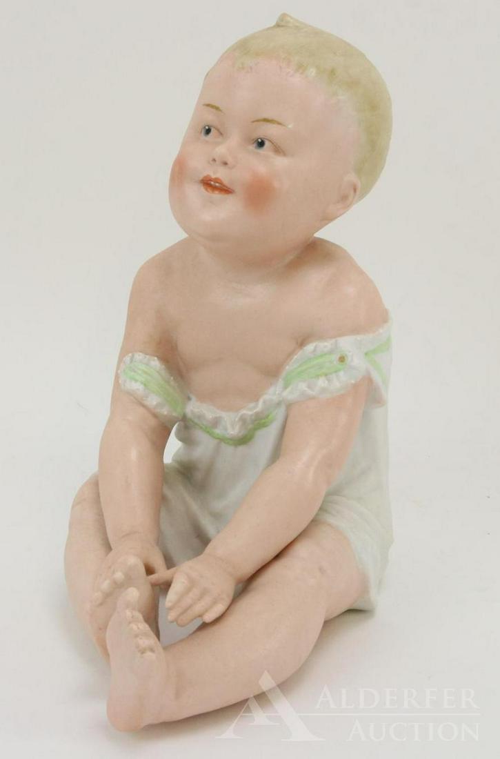 BISQUE FIGURINE LOT: 8" T HEUBACH sitting piano baby marked with Heubach sunburst. Blue integlio eyes. Condition: nothing observed on bisque.