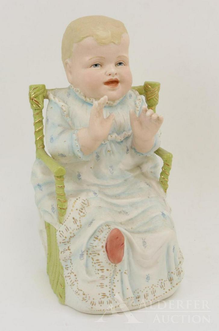 BISQUE FIGURINE LOT: 11" T Baby on green chair marked R (with crossed swords symbol). Condition: a small pock mark on each cheek. Nothing else observed on bisque.