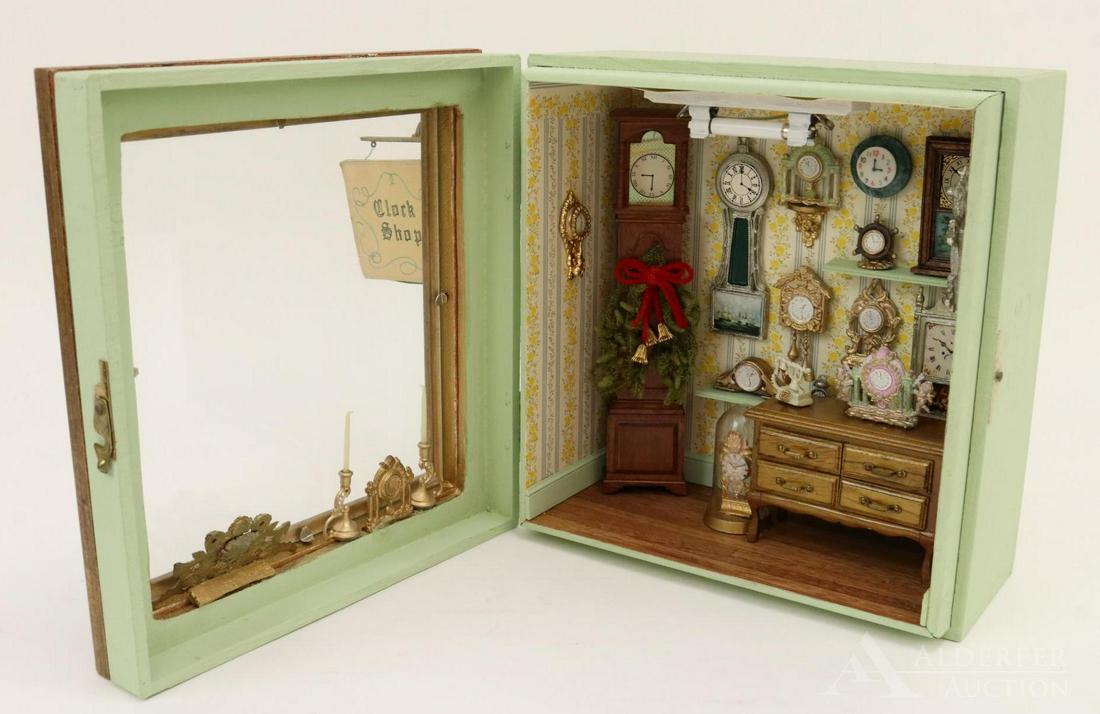 MINIATURE ROOM BOX.: Wooden cigar box 7 1/2" T x 7" D x 4" D. Front of box opens to reveal "Clock Shop". Mounted on the wall are (11) clocks. In the display window are two clocks and a pair of brass candlesticks. On the f