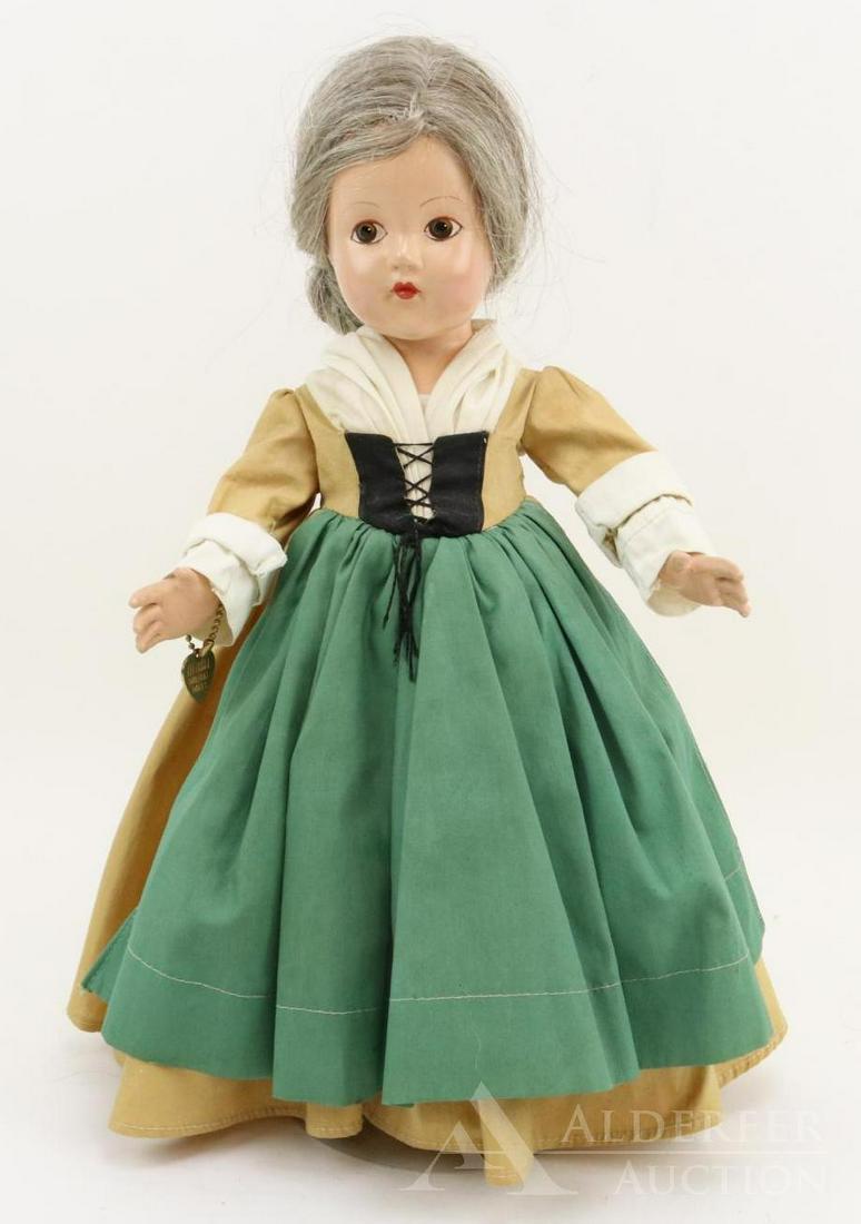 COMPOSITION EFFANBEE HISTORICAL DOLL.: 14" 1939 All original "1682 Quaker Settlement" doll. Painted brown eyes, gray human hair wig. Dressed in gold cotton dress with attached green "apron", white detail. Petticoat, pantaloons. Black oilcl
