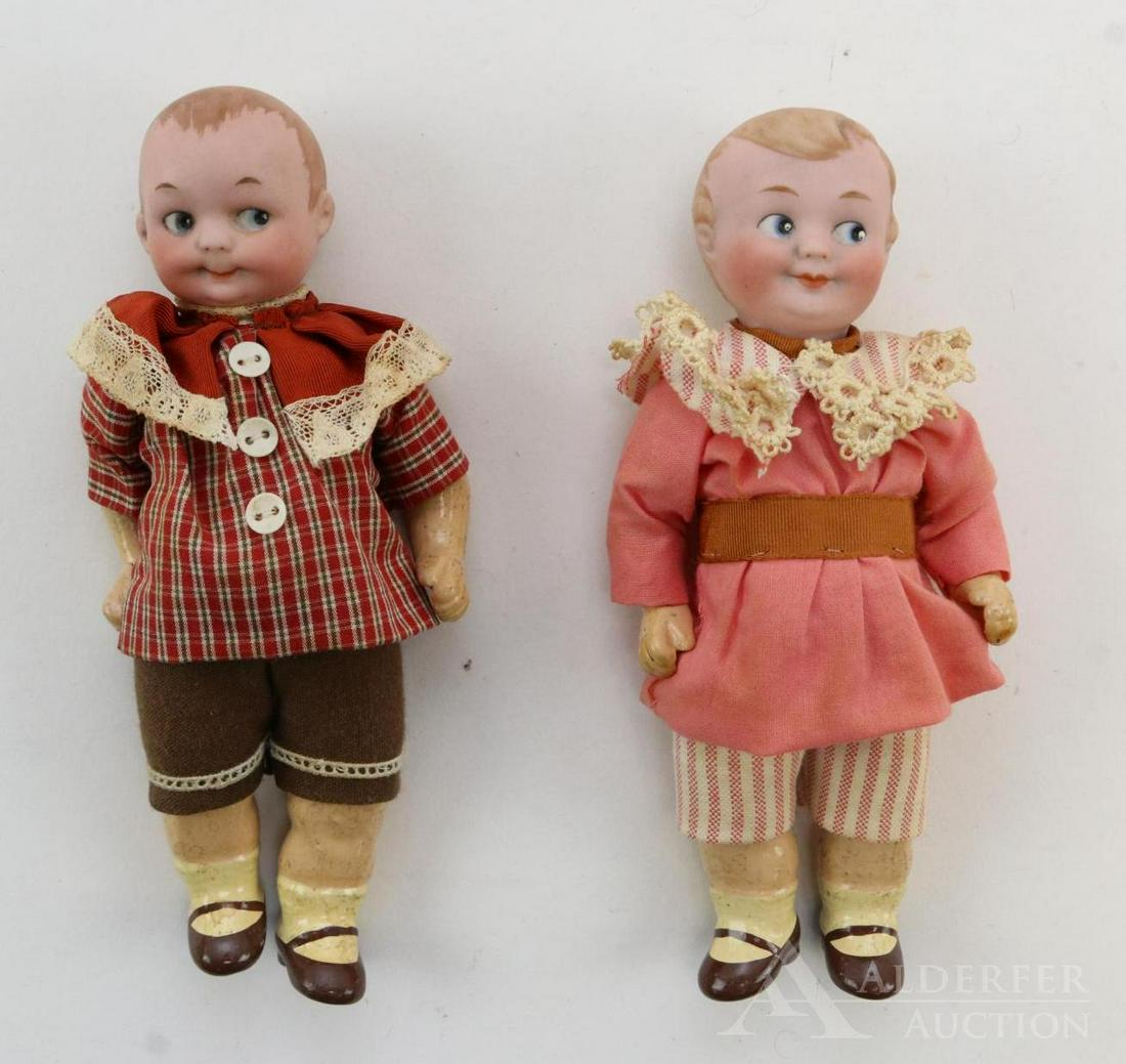 GERMAN BISQUE HEAD DOLLS 12" AND UNDER.: Pair of solid dome Googly eye character dolls. Both dolls have blue integlio eyes, painted hair, closed mouths, 5 pc. papier mache bodies with painted brown shoes. Attractively redressed in vintage cl