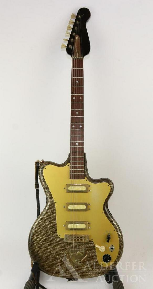 Vintage Electric Guitar: c.1960s. Plasticized vinyl body covering w/gold-flecked paint. Hagstrom tremolo tailpiece. Unmarked and no serial #. Hard shell case.