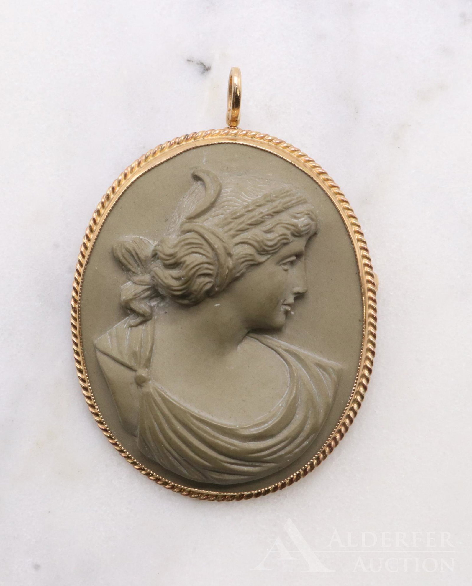 14KY Gold Lava Cameo Brooch Pendant: High relief lava cameo of a right facing classical female bust is bezel set in a fine rope edged frame etched with the hallmark of Wesley Emmons. 1.5 x 1.25" oval. Frame has a hinged bail and a pin