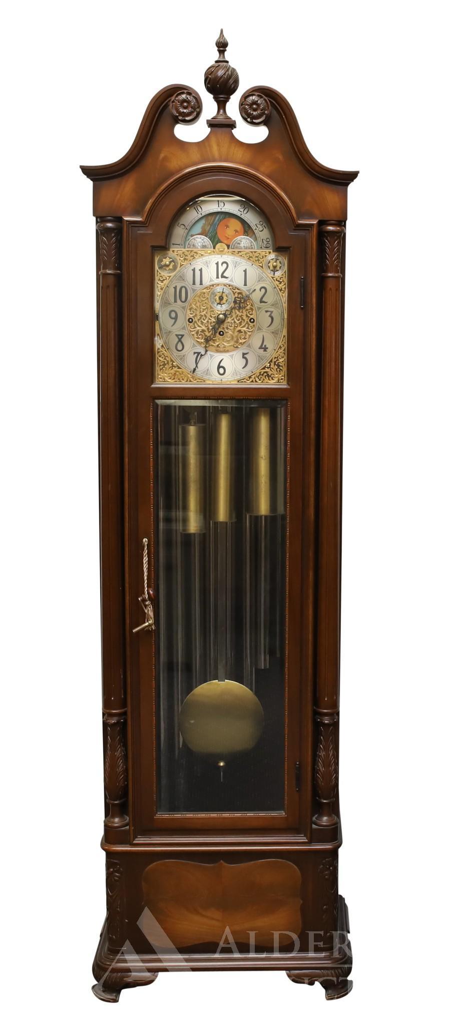 Hershede Chime Clock: Mahogany case with a broken arch pediment with a flame finial, fluted and acanthus carved columns on ogee feet. 8 day movement with Whittington, Westminster, and Canterbury chimes, ornate ormolu moon 