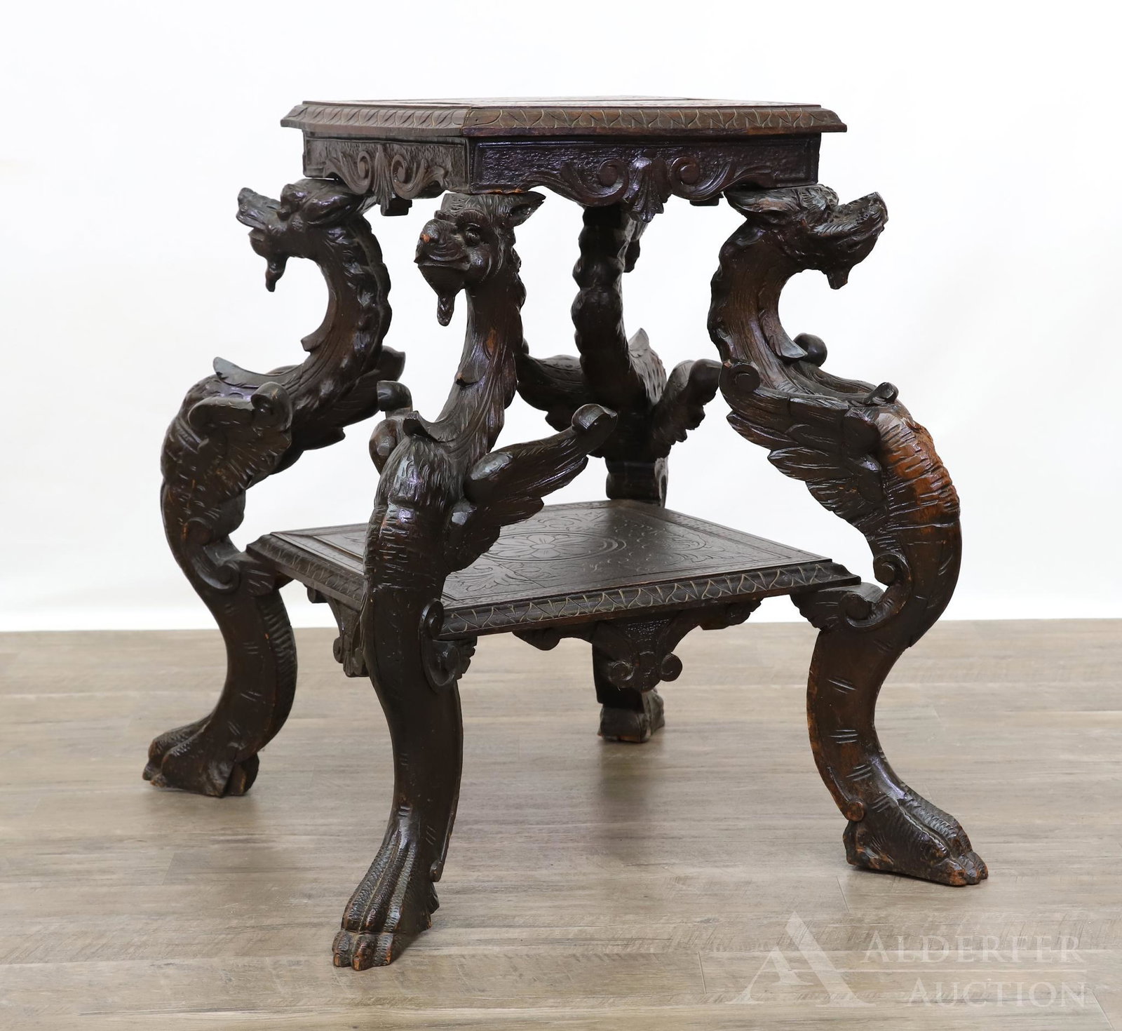 Renaissance Revival Griffin Carved Oak Occasional Table: Two floral and foliate engraved tiers with carved friezes with ornate scrolled griffin carved legs terminating in paw. 28.75h" x 27w" x 25d"