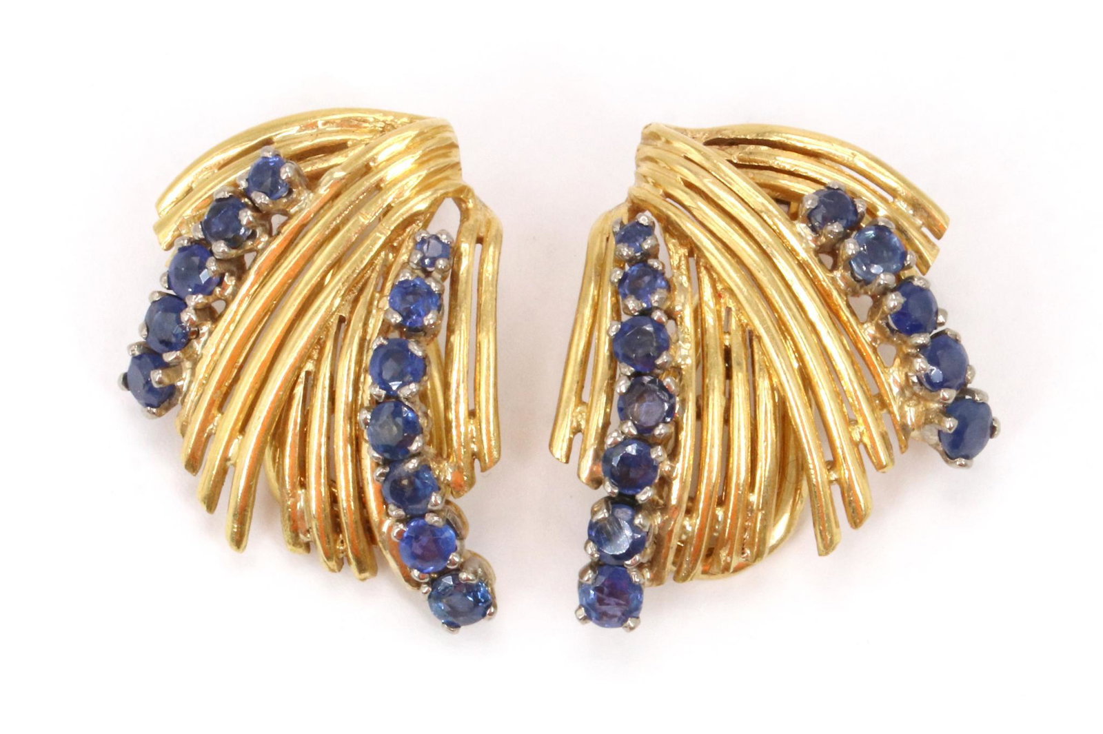 18KY Gold Sapphire Earrings: Each yellow gold omega back clip on earring features (12) round blue sapphires set in white gold heads. Originally post earrings, posts appear to be clipped down. 1". 12.2gtw
