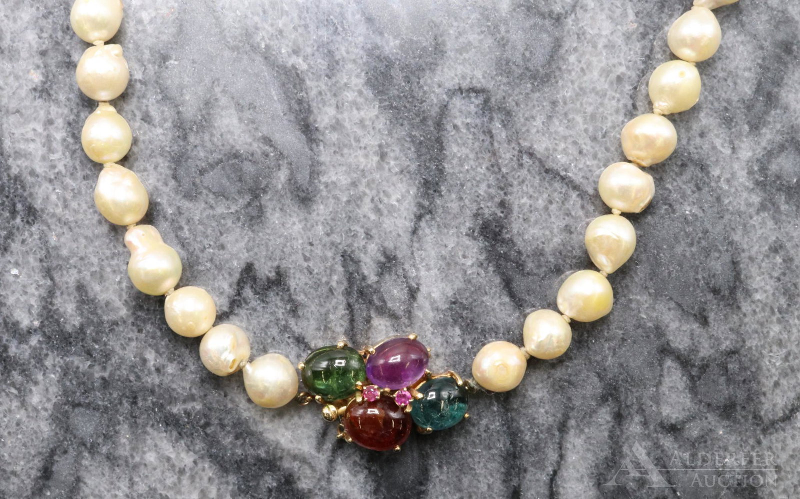 14KY Gold Gemstone Pearl Necklace with Jeweled Clasp: Opera length strand of baroque pearls. clasp enhanced by (1 each) oval blue, green and rose tourmaline and amethyst cabochons, accented by (2) round faceted Ruby accents. Approx. 9mm pearls, 30" long.