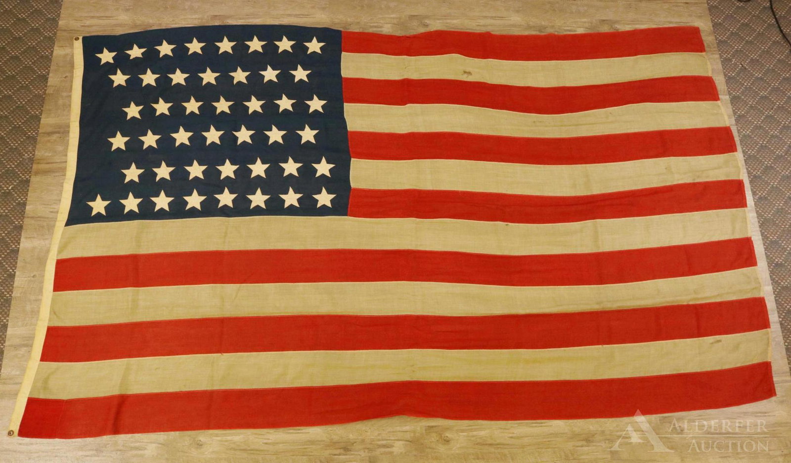 Historic 44-Star United States Flag: United States 44-star flag (8-7-7-7-7-8 configuration) of linsey-woolsey construction and machine sewn. Flag measures 68" x 116" and presents brass grommets on pole edge. Flag exhibits toning. The 44-