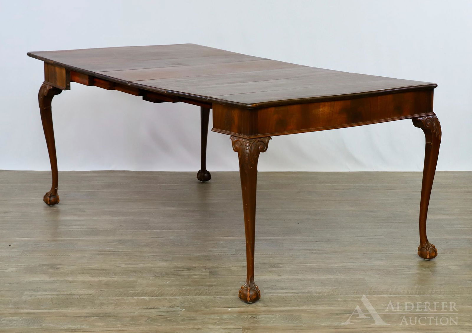 Chippendale Style Extension Table: Extending dining/card table of mahogany and mahogany veneer with a shaped top and carved cabriole legs terminating in ball and claw feet. 31"h x 38"w (76"w extended) x 20"d with three 12" leaves