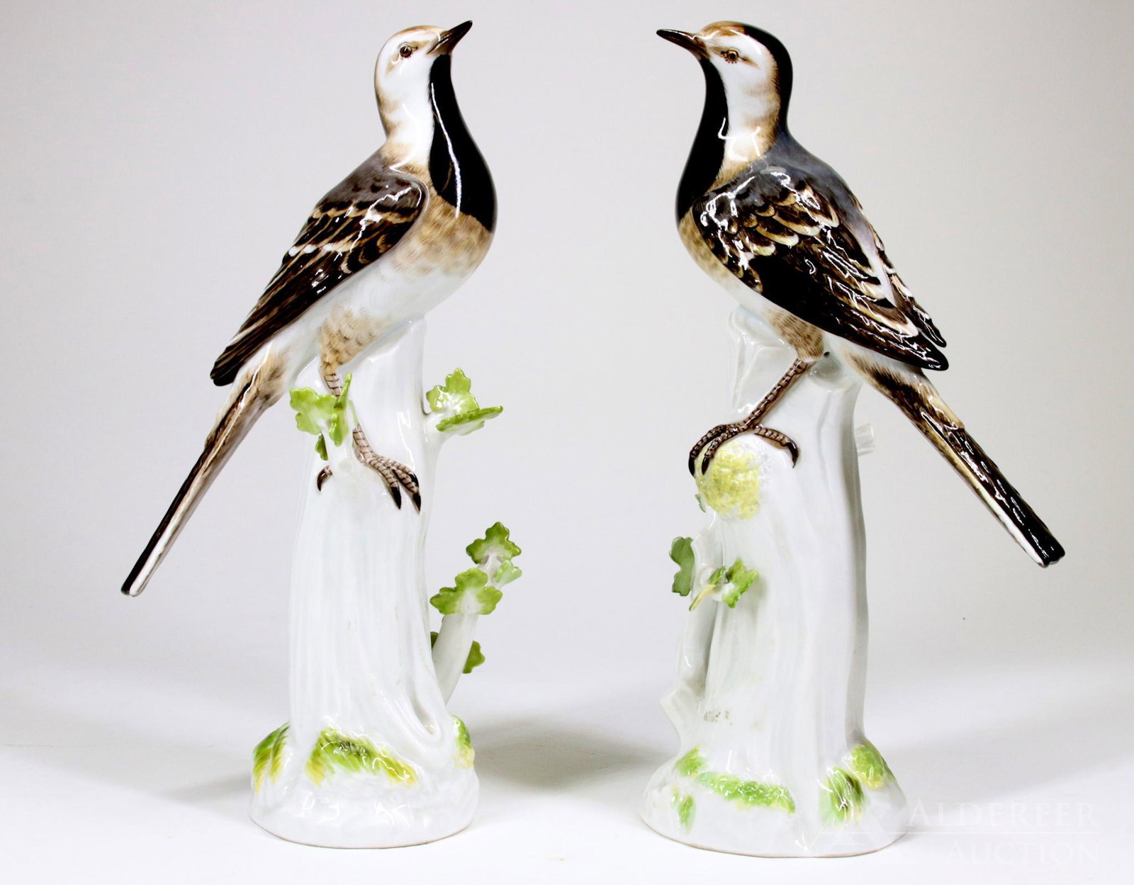 Meissen Porcelain Models of Birds: 20th century, pair of Meissen birds perched on white stump with green leaves. Blue underglaze crossed swords and marked 58. 9"h x 4.5"w