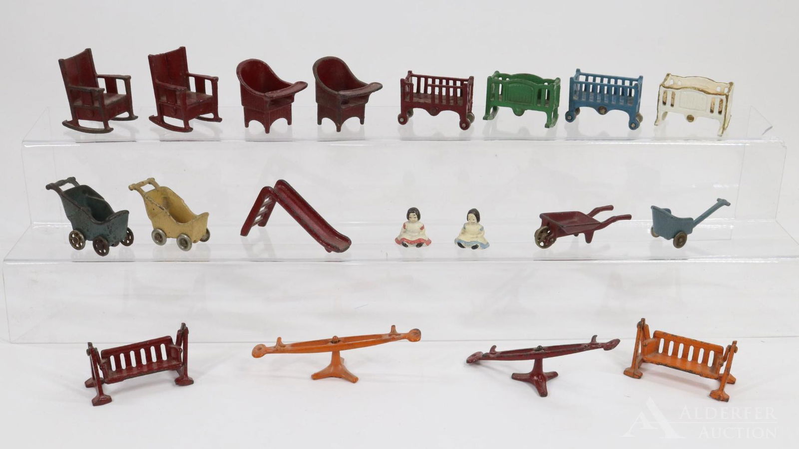 LOT OF MINIATURES.: Lot of cast iron toys. (1) Pc. is marked KILGORE. Carriages, chairs, rocking chairs, cribs, sliding board, see-saws, gliders, wheelbarrow, cart, (2) dolls. Condition: paint loss, age loss/ discolorati